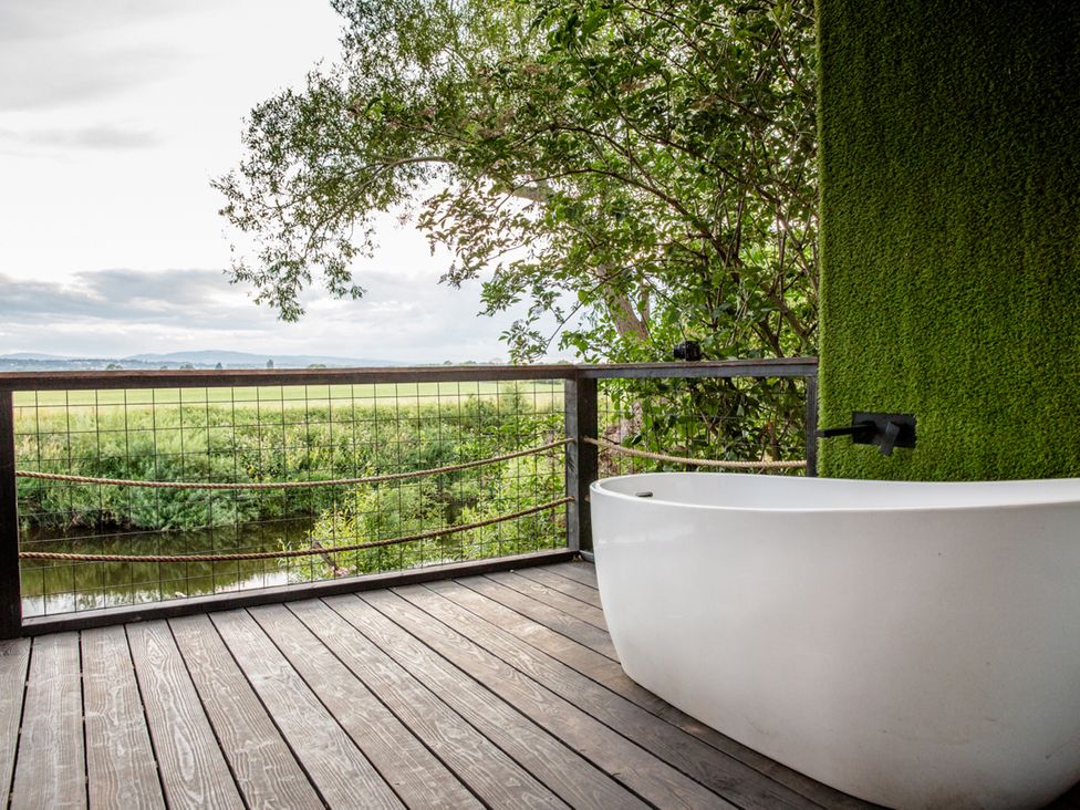 An outdoor bathing area with a tub and plants at The Red House Farndon