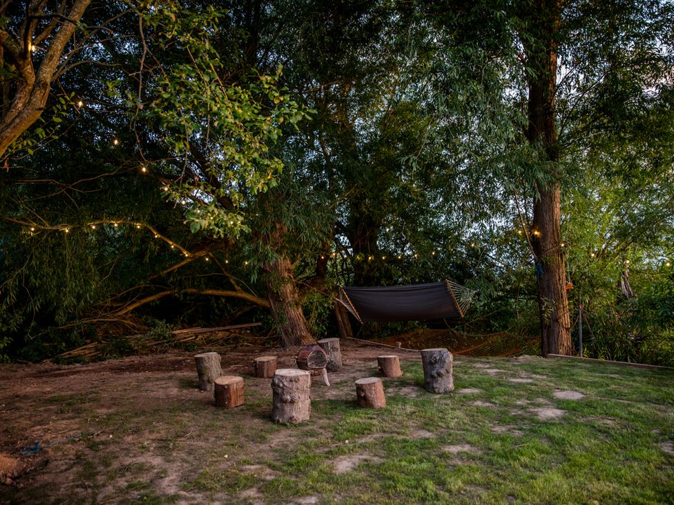 An outdoor area with tree stumps and a hammock at The Red House in Farndon