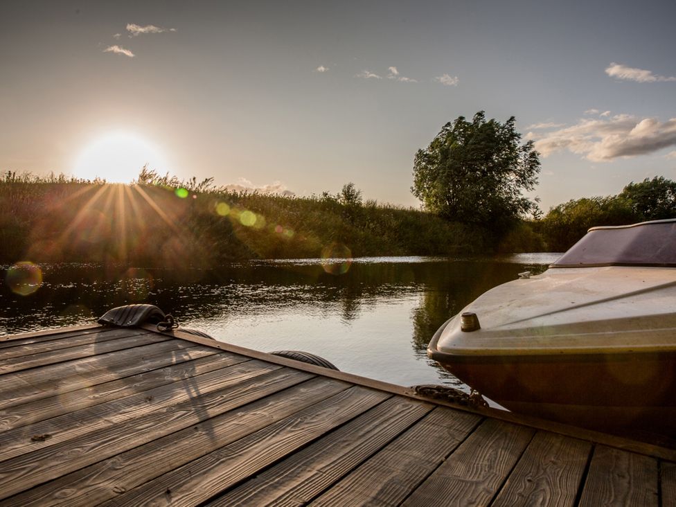A boat near a dock with a sunset at The Red House in Farndon