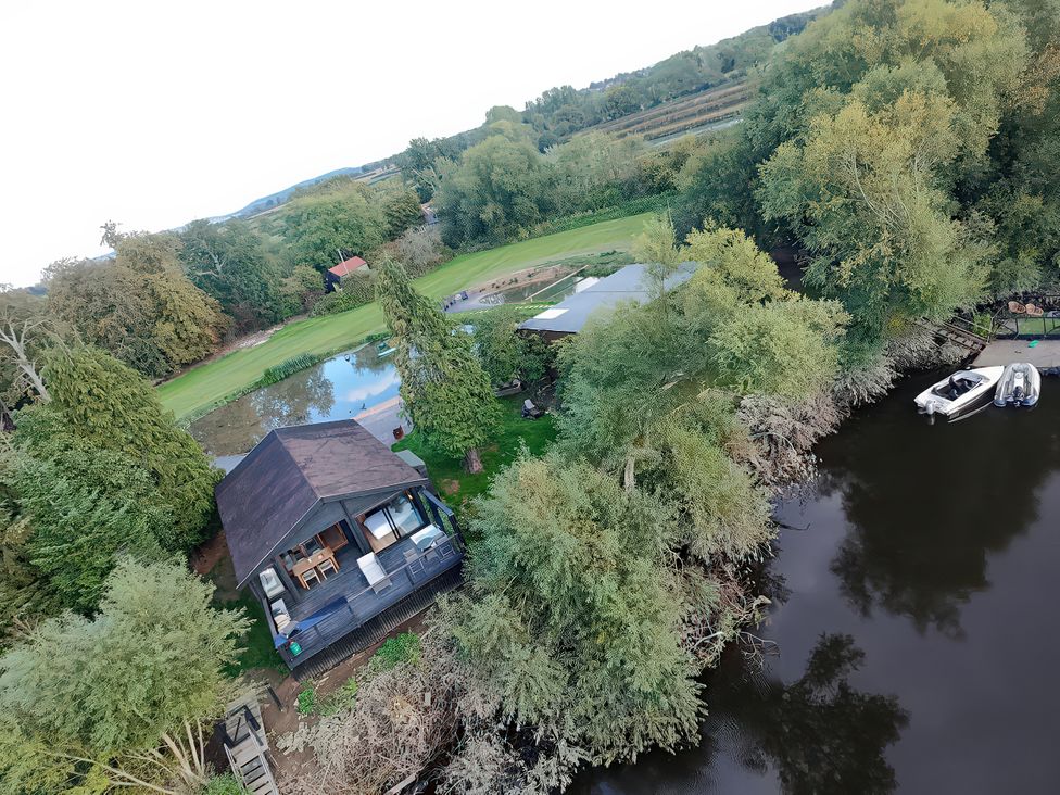 An outdoor view of a house near a river and golf course at The Red House in Farndon