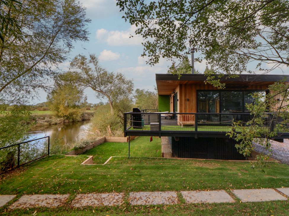 A house with a balcony overlooking a river at The Red House in Farndon