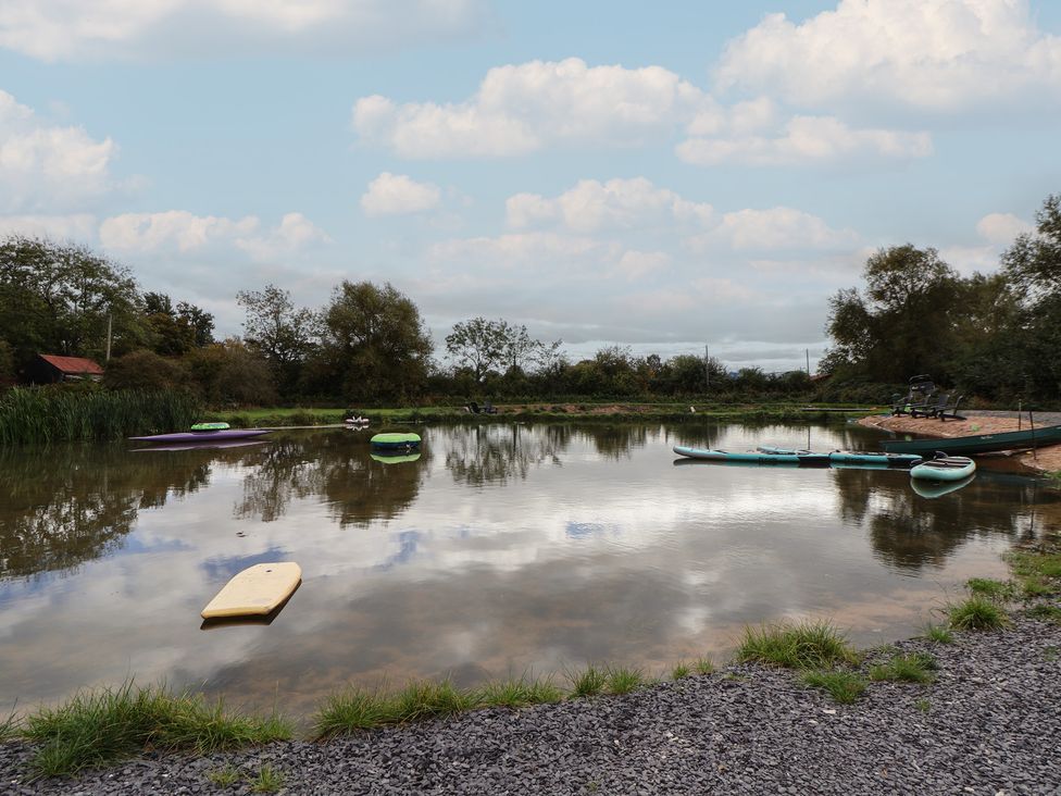 A pond with kayaks and paddleboards at The Red House in Farndon