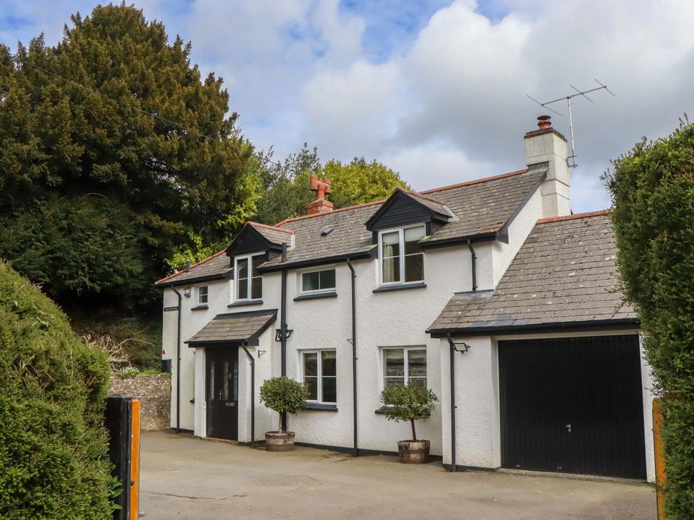 A house with a garage and trees at Town Farm Cottage in Barnstaple