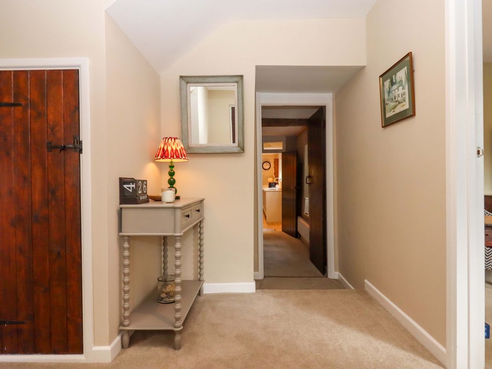 A hallway with a table and a door at Town Farm Cottage Barnstaple
