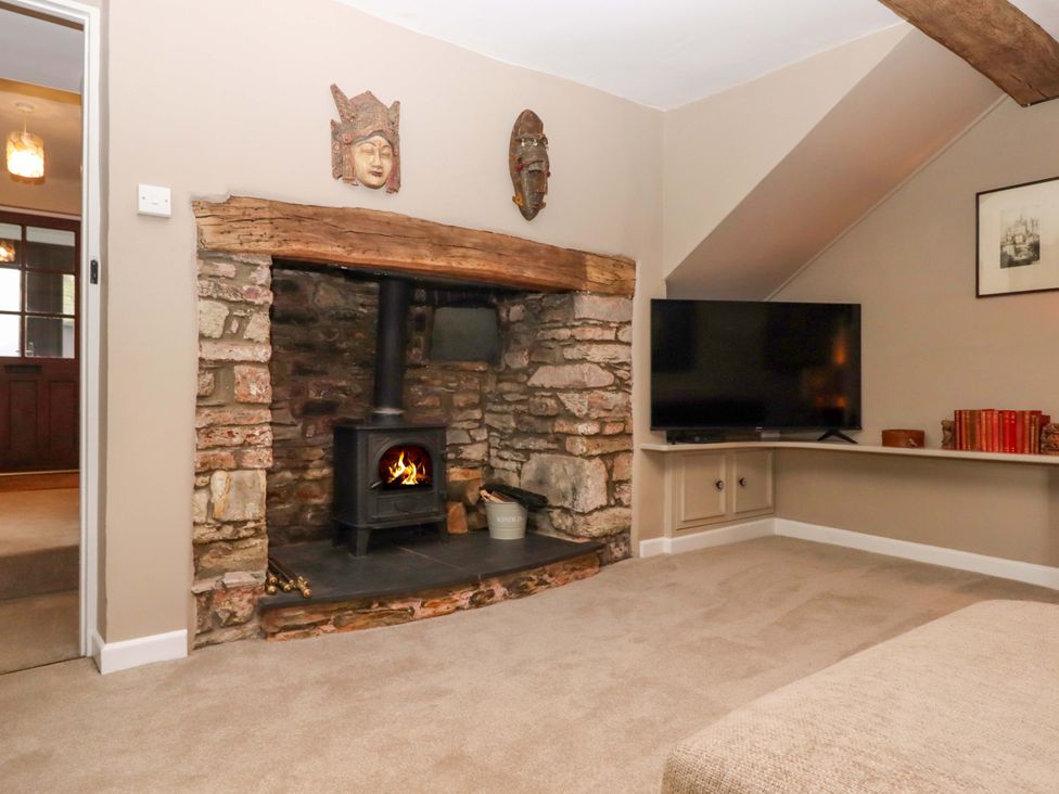 A living room with a fireplace and television at Town Farm Cottage in Barnstaple