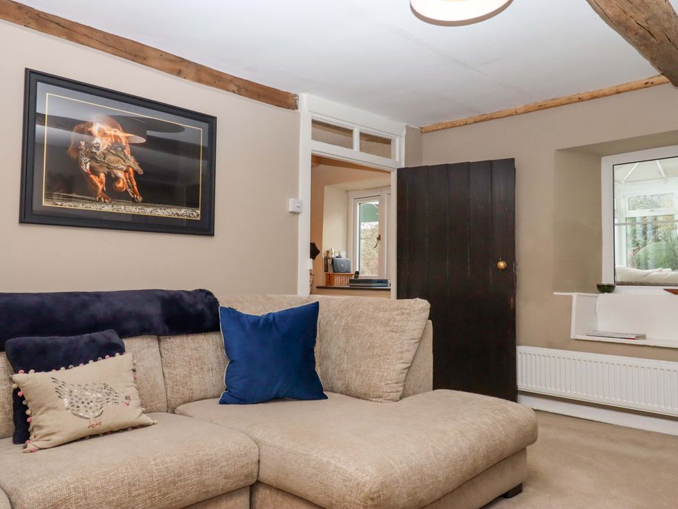 A living room with a sofa and painting at Town Farm Cottage in Barnstaple