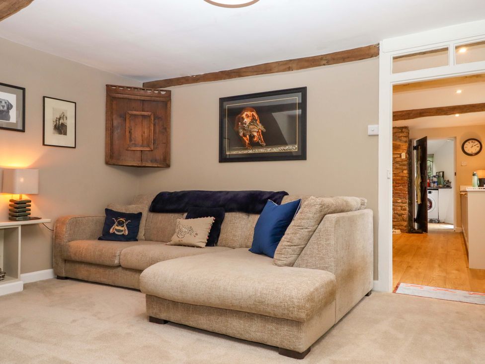 A living room with a sofa and pictures on the wall at Town Farm Cottage in Barnstaple
