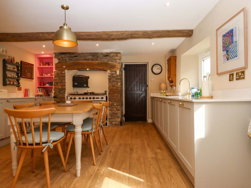 A kitchen with a dining table and wooden chairs at Town Farm Cottage Barnstaple