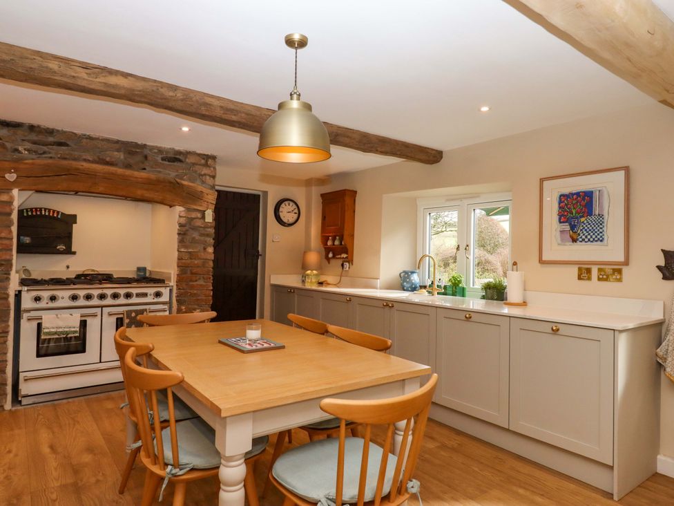 A kitchen with a dining table and oven at Town Farm Cottage in Barnstaple
