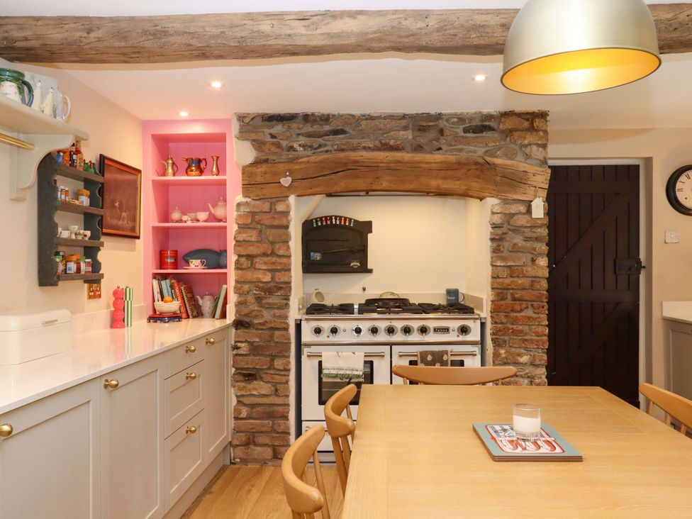 A kitchen featuring a stove and wooden table at Town Farm Cottage in Barnstaple