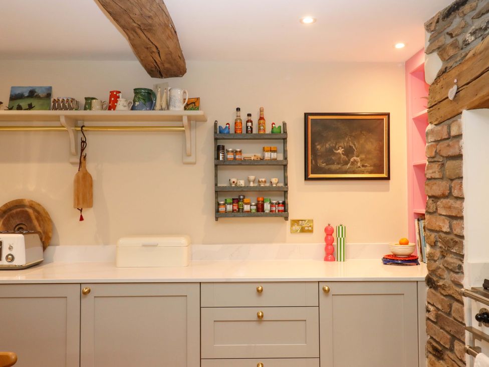 A kitchen with a shelf and spices at Town Farm Cottage Barnstaple
