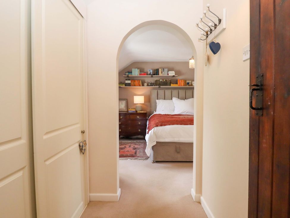 A bedroom with an archway leading to the bed at Town Farm Cottage in Barnstaple