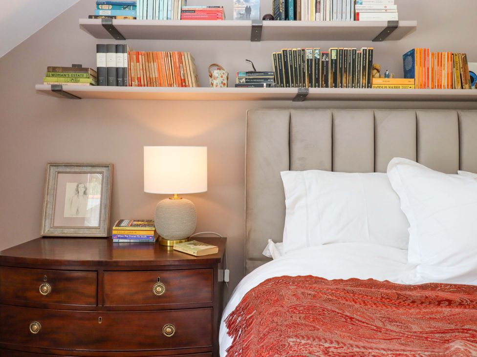 A bedroom with a bed and bookshelf at Town Farm Cottage Barnstaple