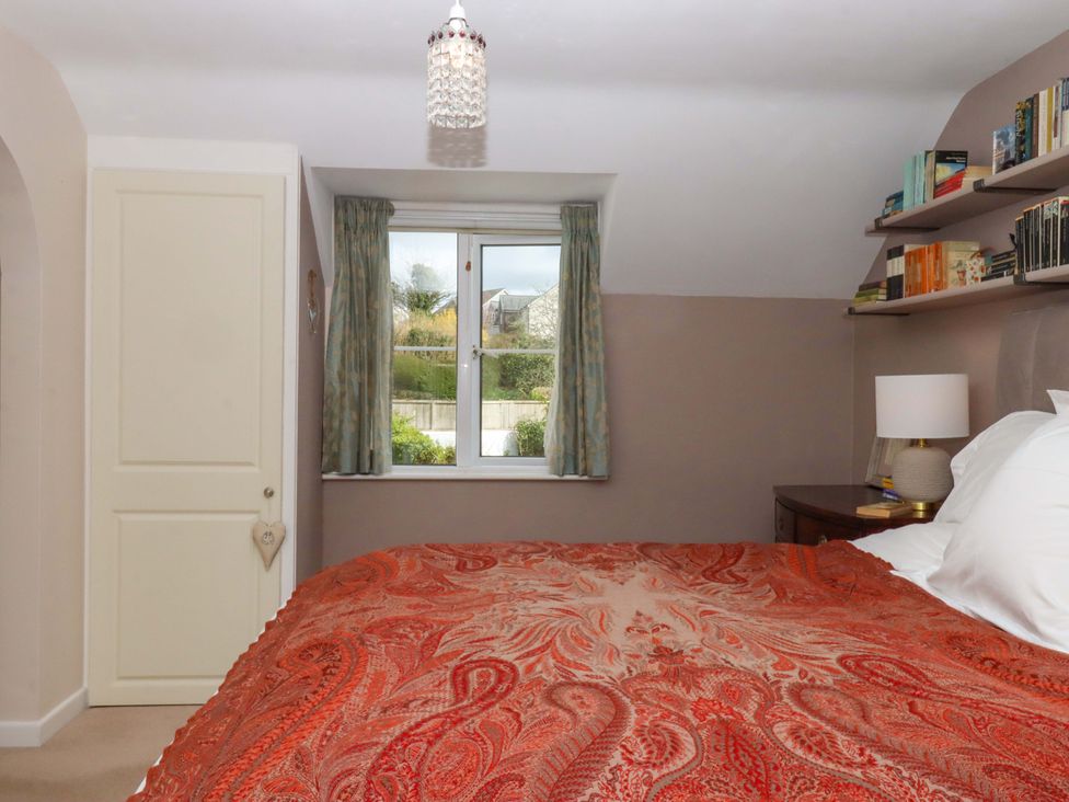 A bedroom with a bed and a window at Town Farm Cottage in Barnstaple