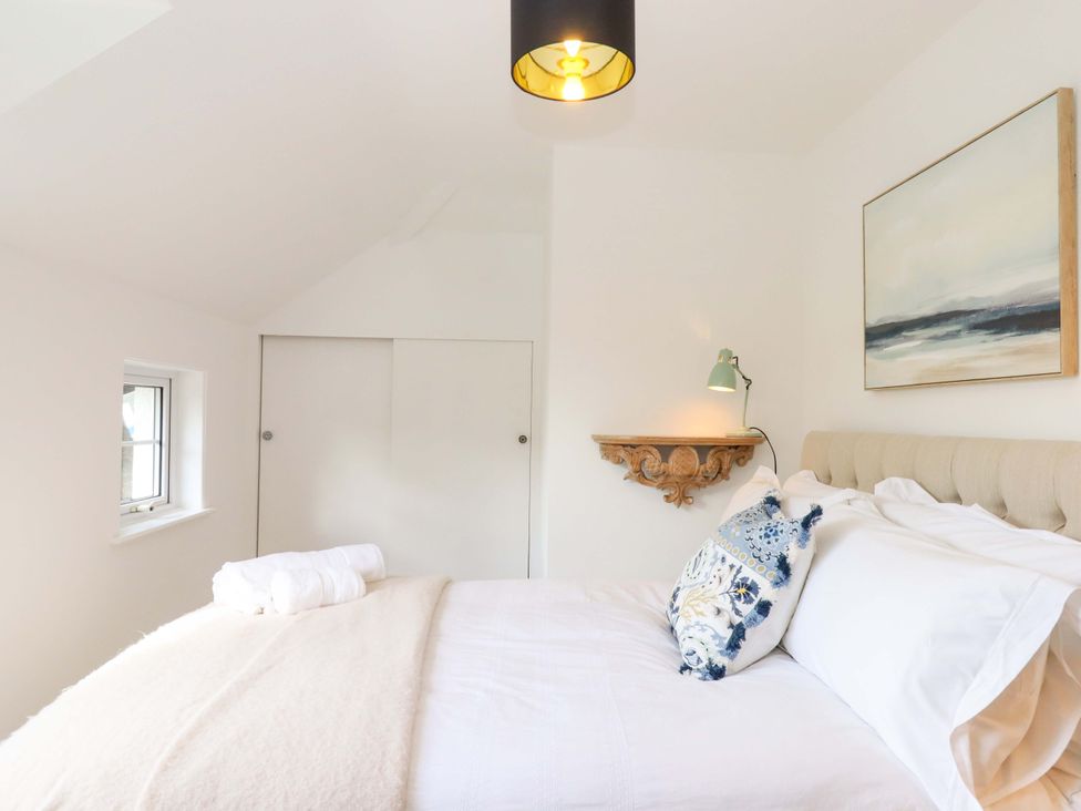 A bedroom with a bed and a window at Town Farm Cottage Barnstaple