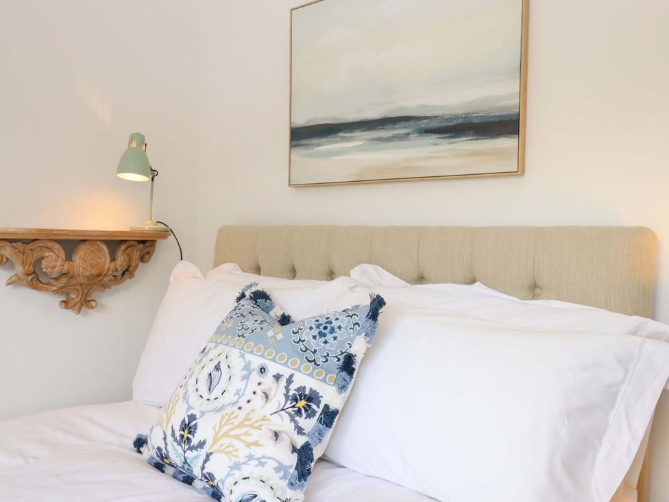 A bedroom with a bed and wall art at Town Farm Cottage in Barnstaple
