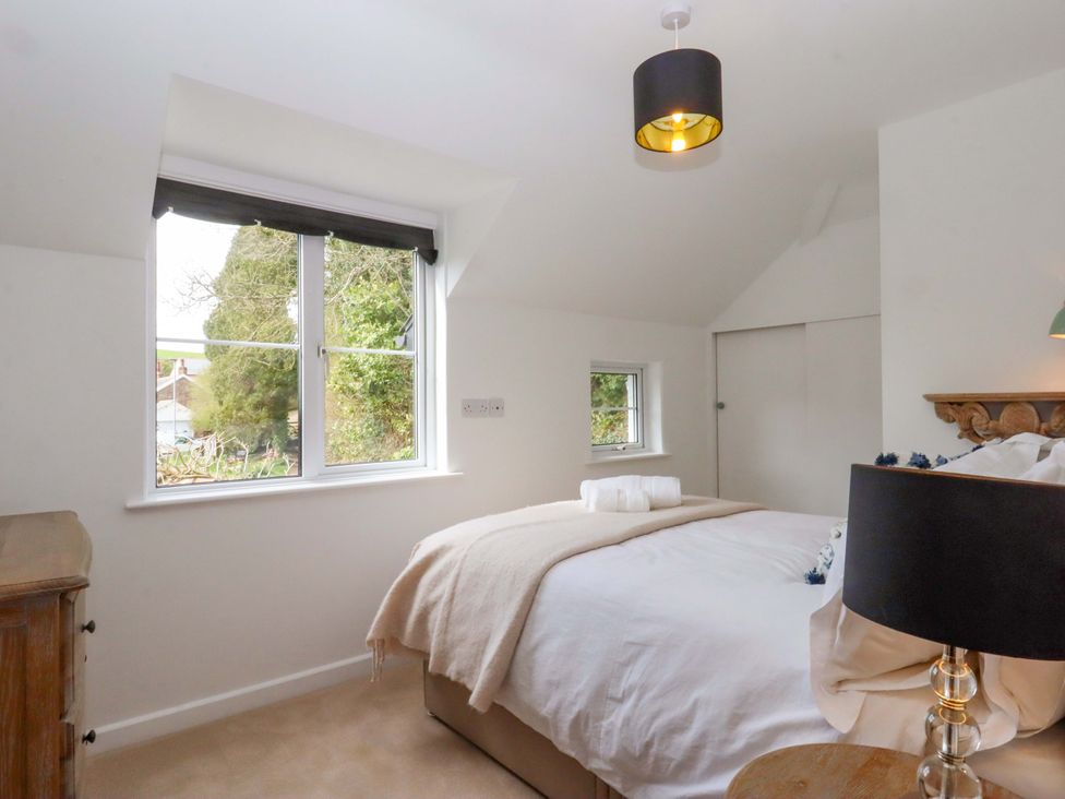 A bedroom with a bed and window at Town Farm Cottage Barnstaple