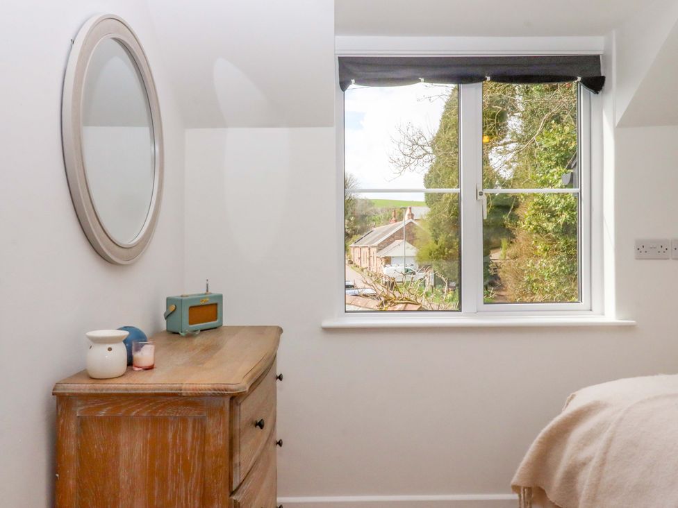 A bedroom with a dresser and a window at Town Farm Cottage Barnstaple
