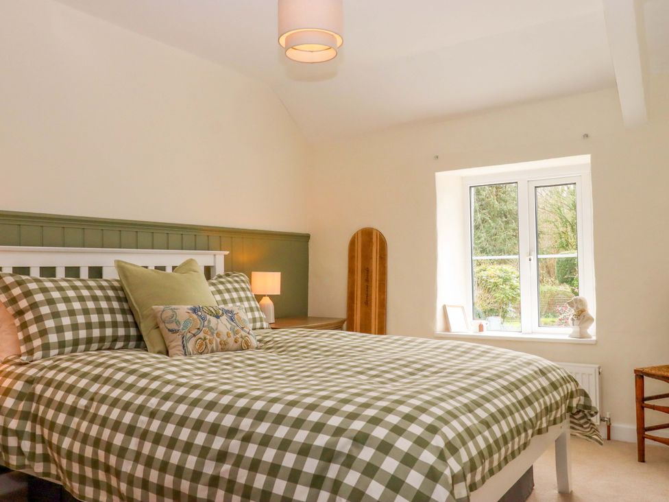 A bedroom with a bed and window at Town Farm Cottage Barnstaple