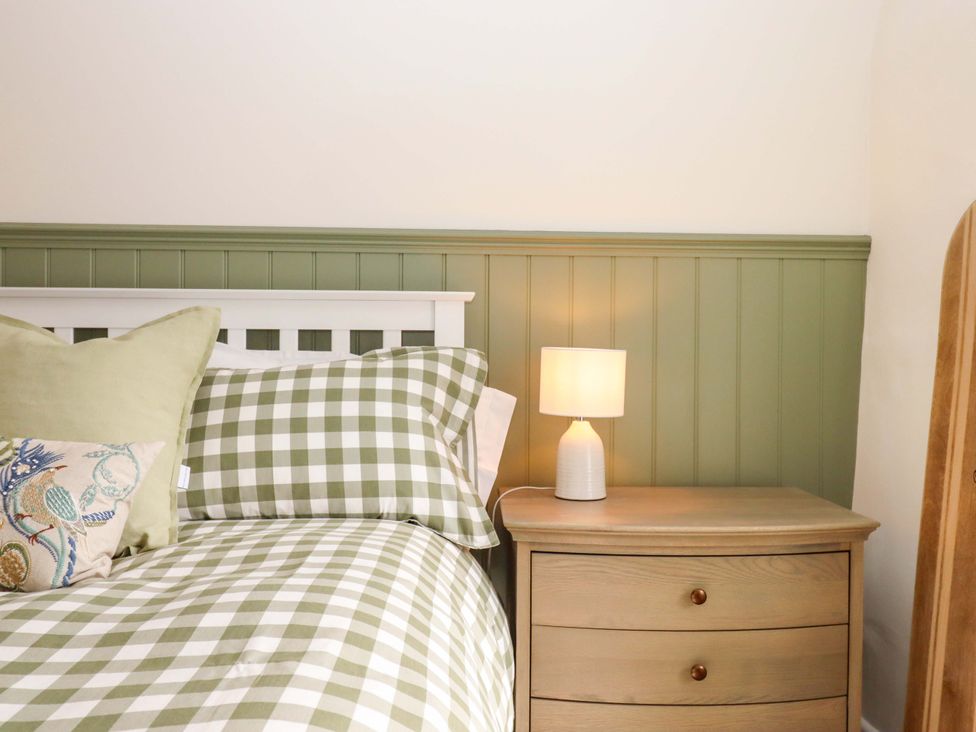 A bedroom with a bed and lamp at Town Farm Cottage in Barnstaple