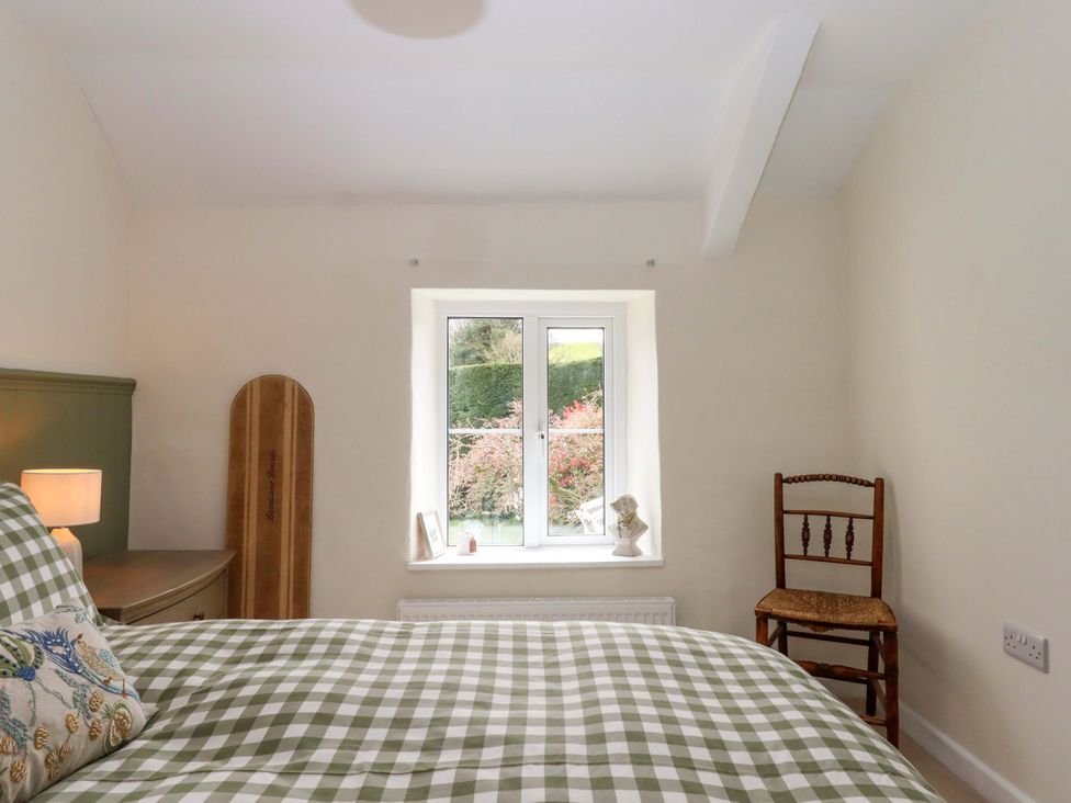 A bedroom with a bed and window at Town Farm Cottage in Barnstaple
