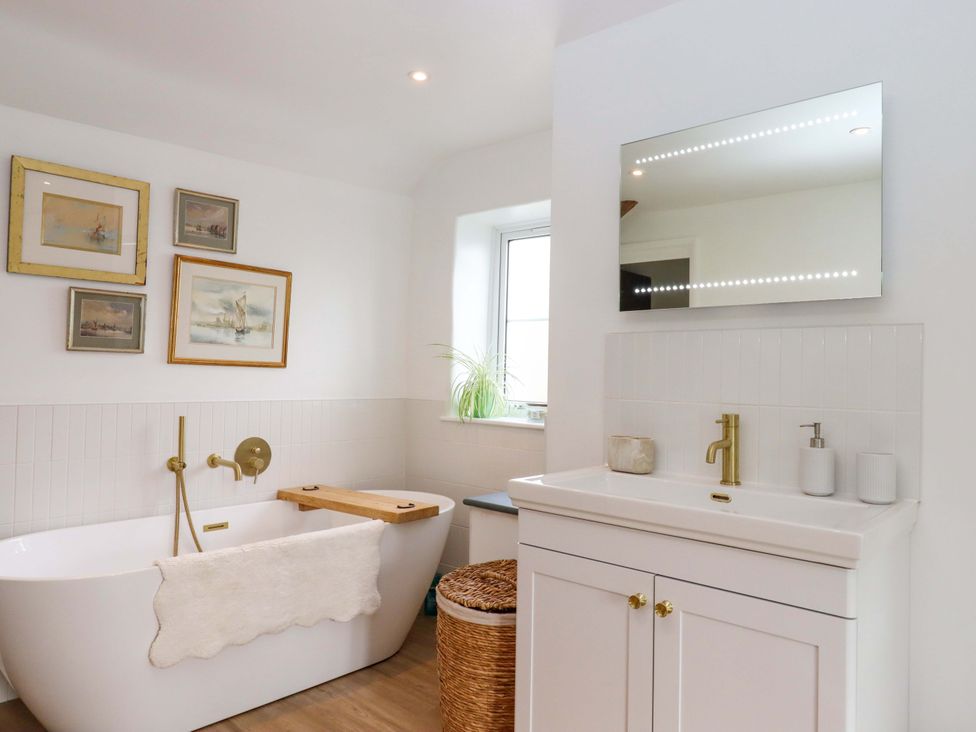 A bathroom with a bathtub and sink at Town Farm Cottage in Barnstaple