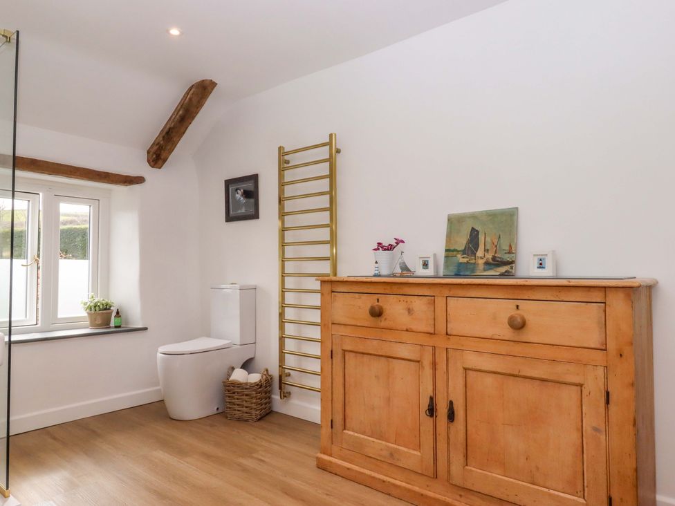 A bathroom with a towel ladder and a toilet at Town Farm Cottage Barnstaple