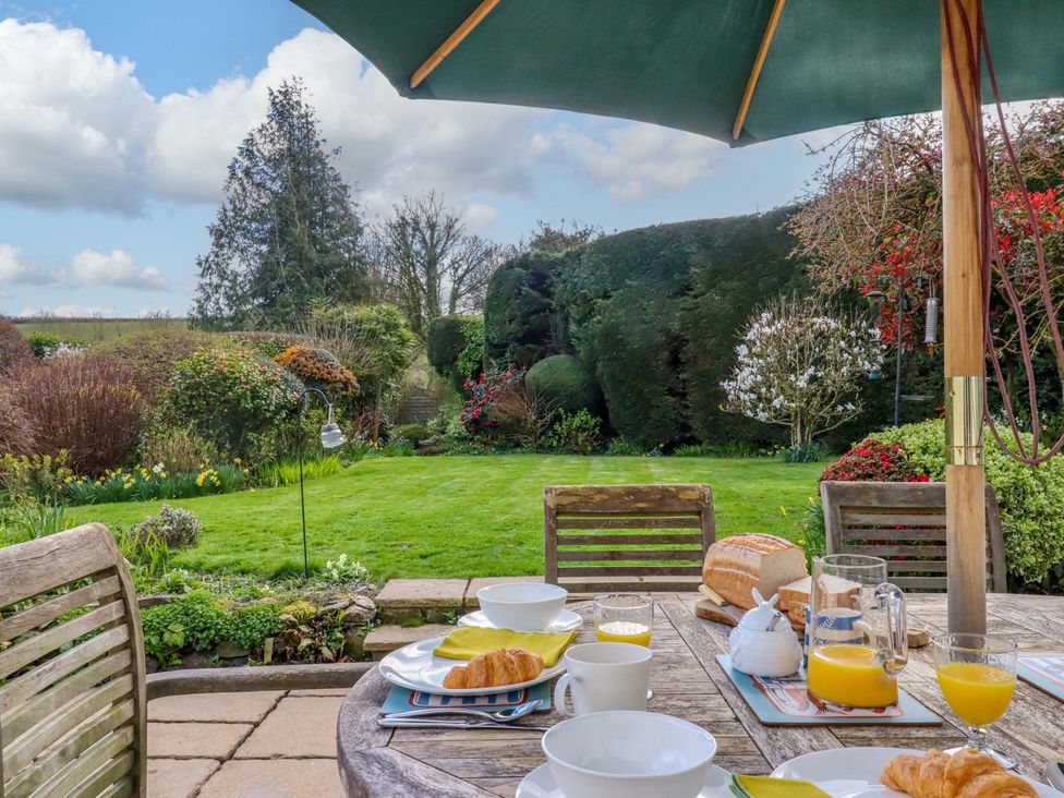A table setting with food and drinks in a garden at Town Farm Cottage in Barnstaple