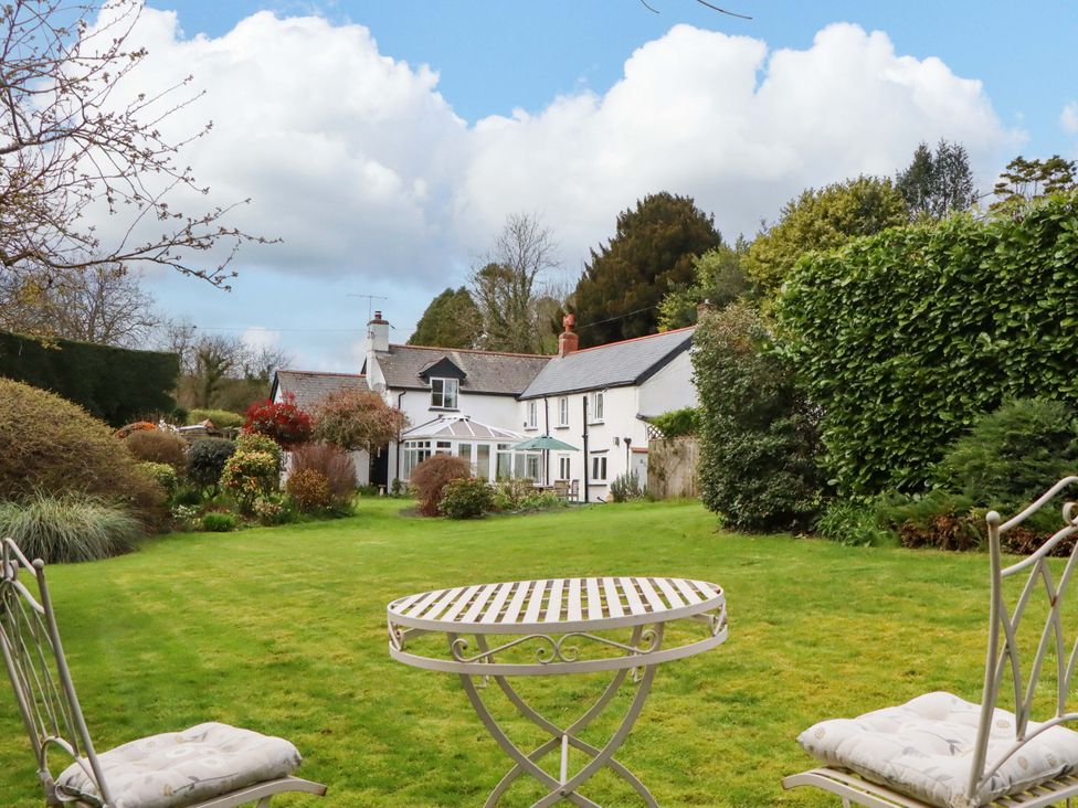 A garden with a house in the background at Town Farm Cottage in Barnstaple