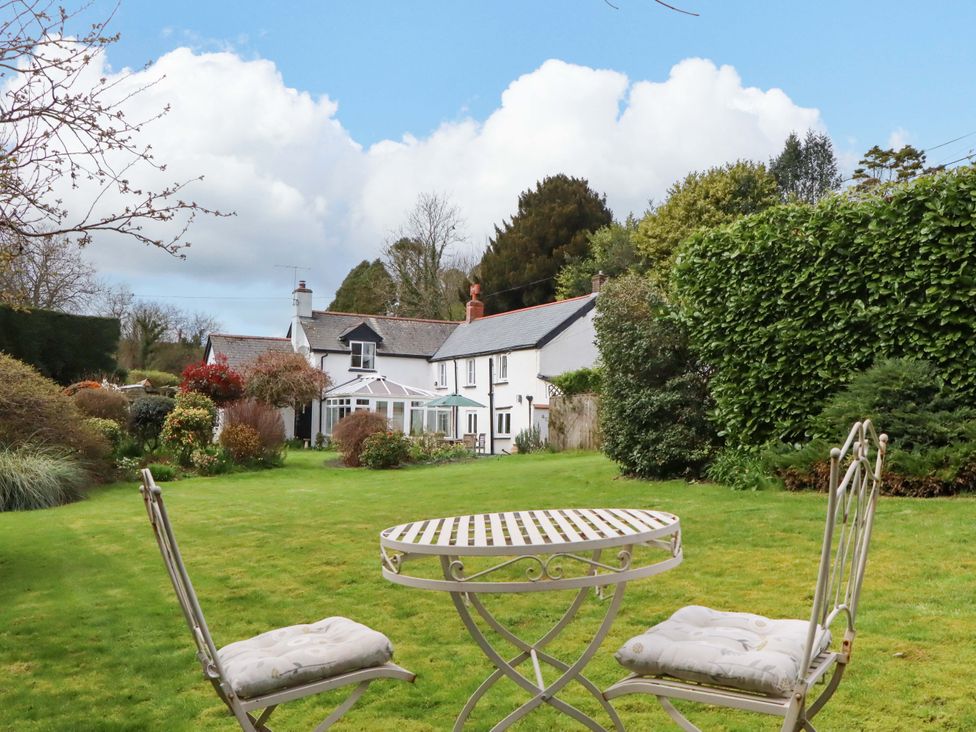 A garden with a table and chairs at Town Farm Cottage in Barnstaple