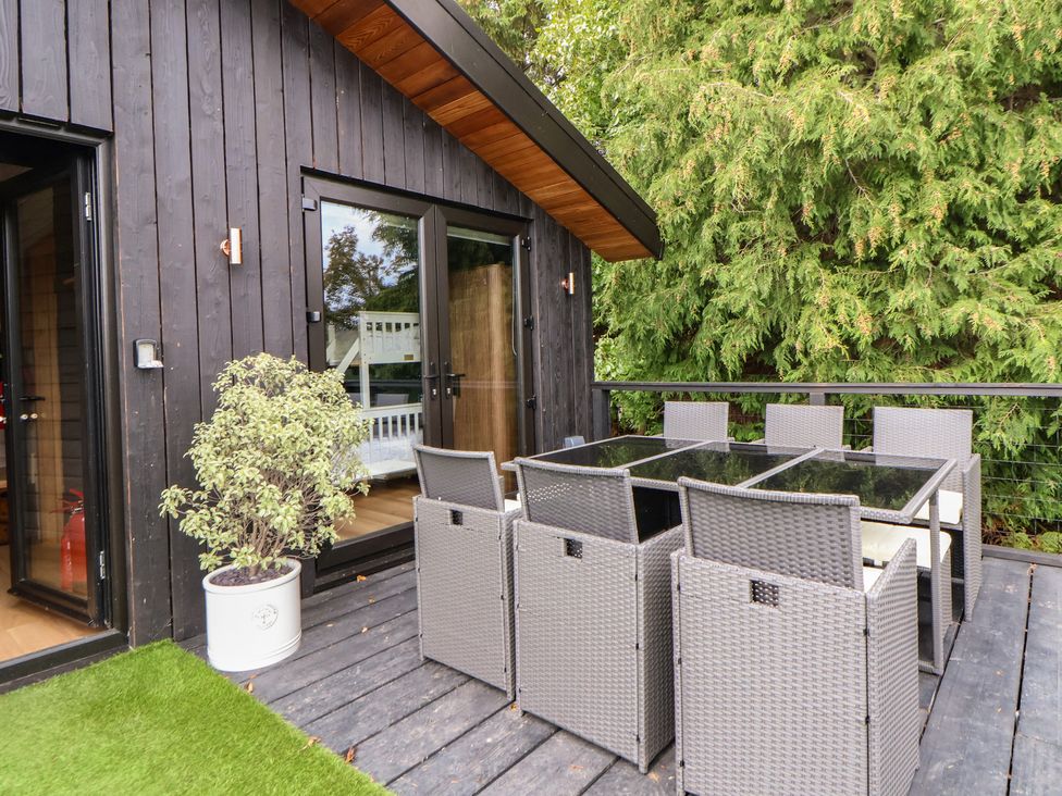 An outdoor seating area with a table and chairs at The Larch House in Farndon