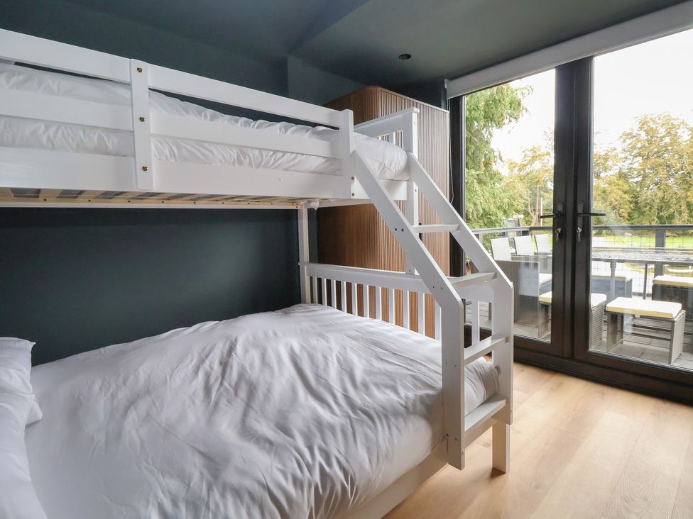 A bedroom with a bunk bed and a double bed at The Larch House Farndon