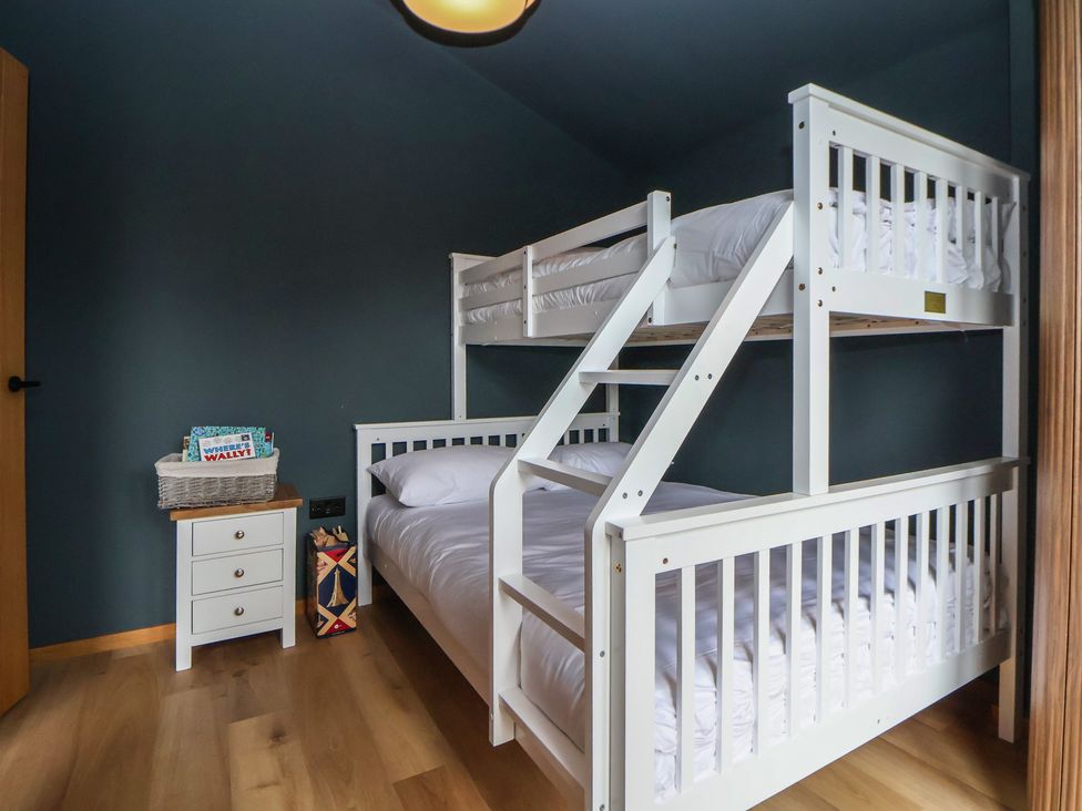 A bedroom with a bunk bed and a single bed at The Larch House in Farndon