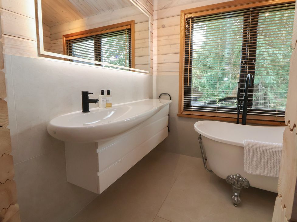 A bathroom with a sink and bathtub at The Larch House in Farndon