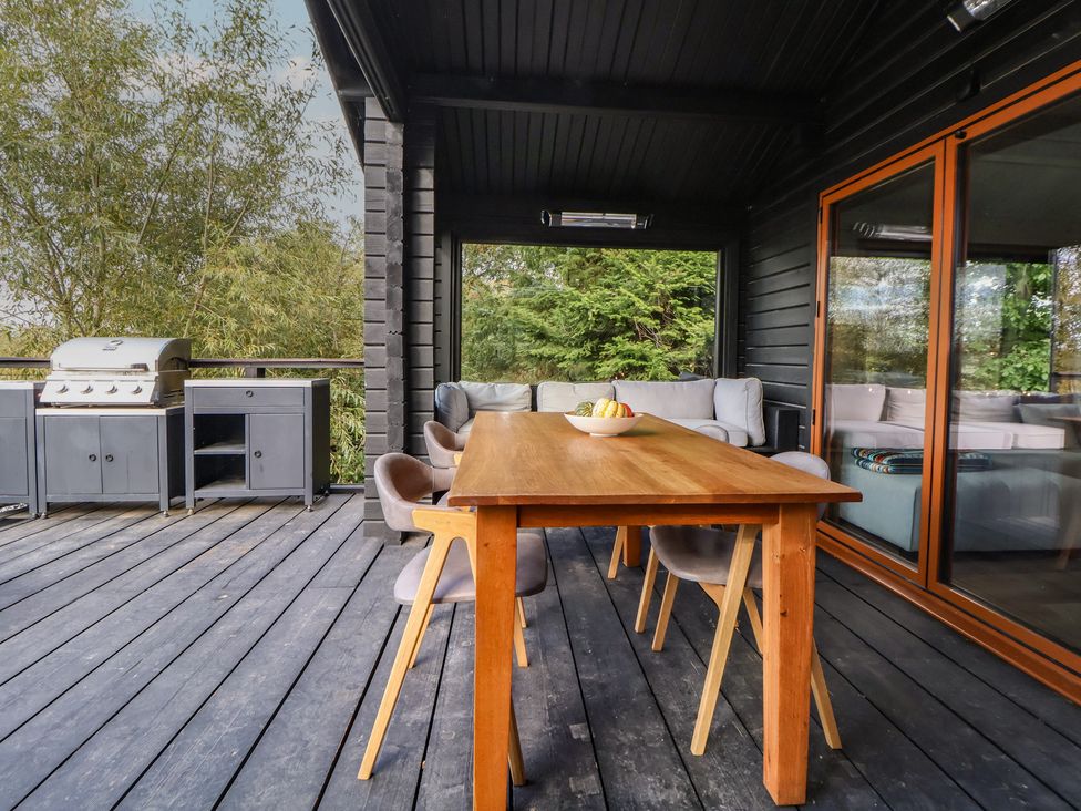 An outdoor dining area with a table and chairs at The Larch House in Farndon