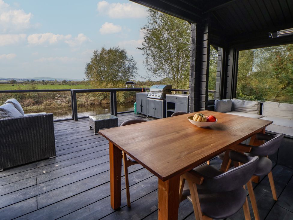 An outdoor dining area with a table and chairs at The Larch House in Farndon