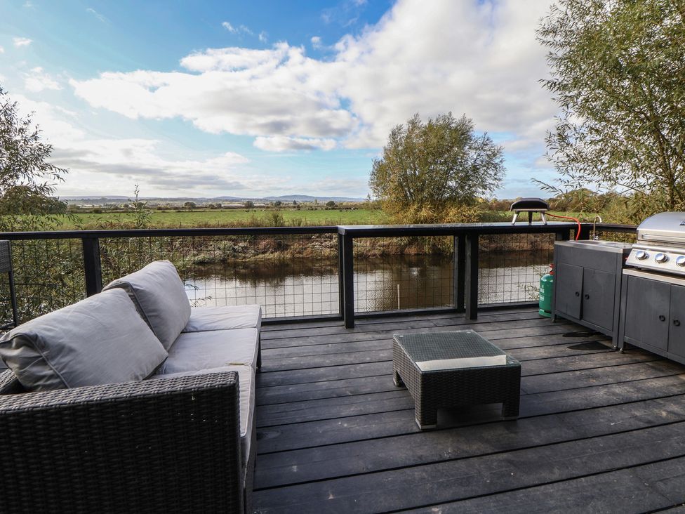 An outdoor space with a sofa and barbecue grill at The Larch House in Farndon