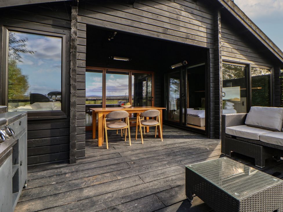 An outdoor area with a table and chairs at The Larch House in Farndon