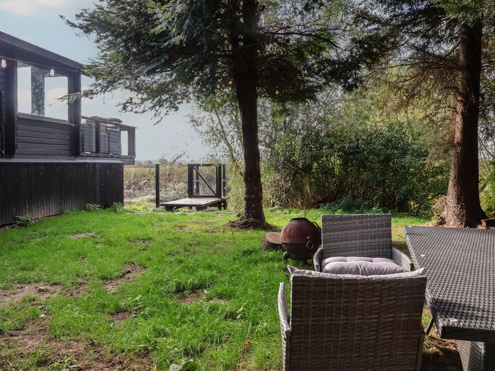 An outdoor area with chairs and a table at The Larch House in Farndon