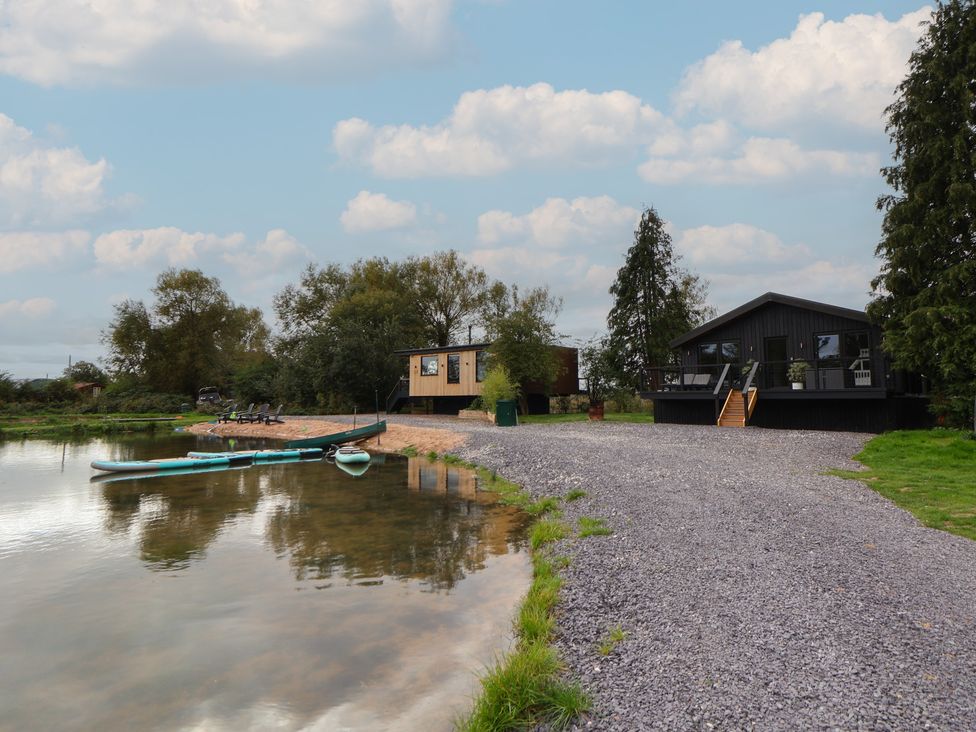 Outdoor area with buildings and canoes at The Larch House in Farndon
