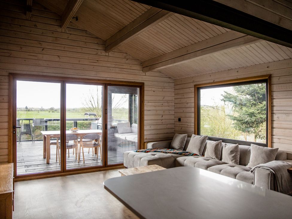 A living room with a sofa and dining area at The Larch House in Farndon