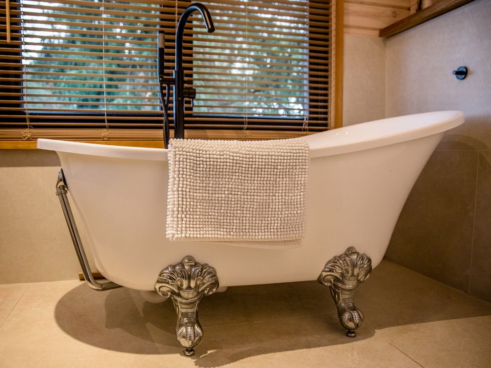 A bathtub with a towel draped over it at The Larch House in Farndon