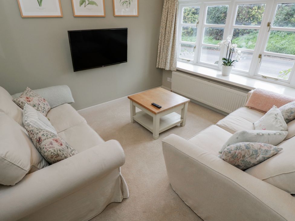 A living room with a sofa and table at Granary Cottage