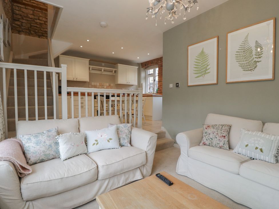 A living room with sofas and a kitchen area at Granary Cottage in 