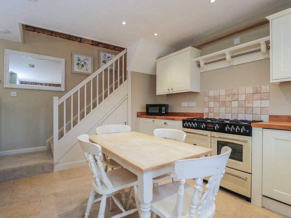 A kitchen with a table and chairs at Granary Cottage