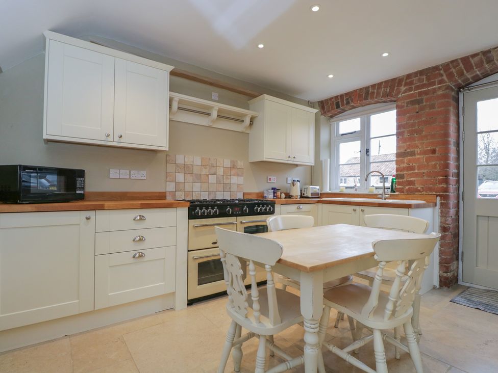 A kitchen with a table and chairs at Granary Cottage 