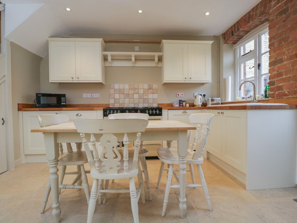 A kitchen with a table and chairs at Granary Cottage