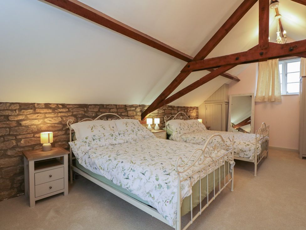 A bedroom with two beds and a nightstand at Granary Cottage in 