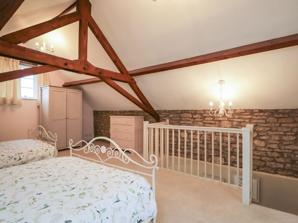 A bedroom with beds and storage furniture at Granary Cottage in 