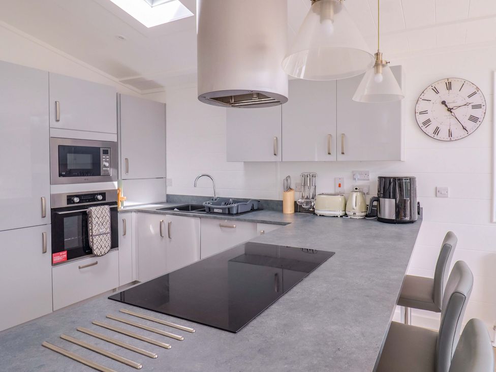 A kitchen with appliances and seating at Cedar 1 Pinewood Retreat